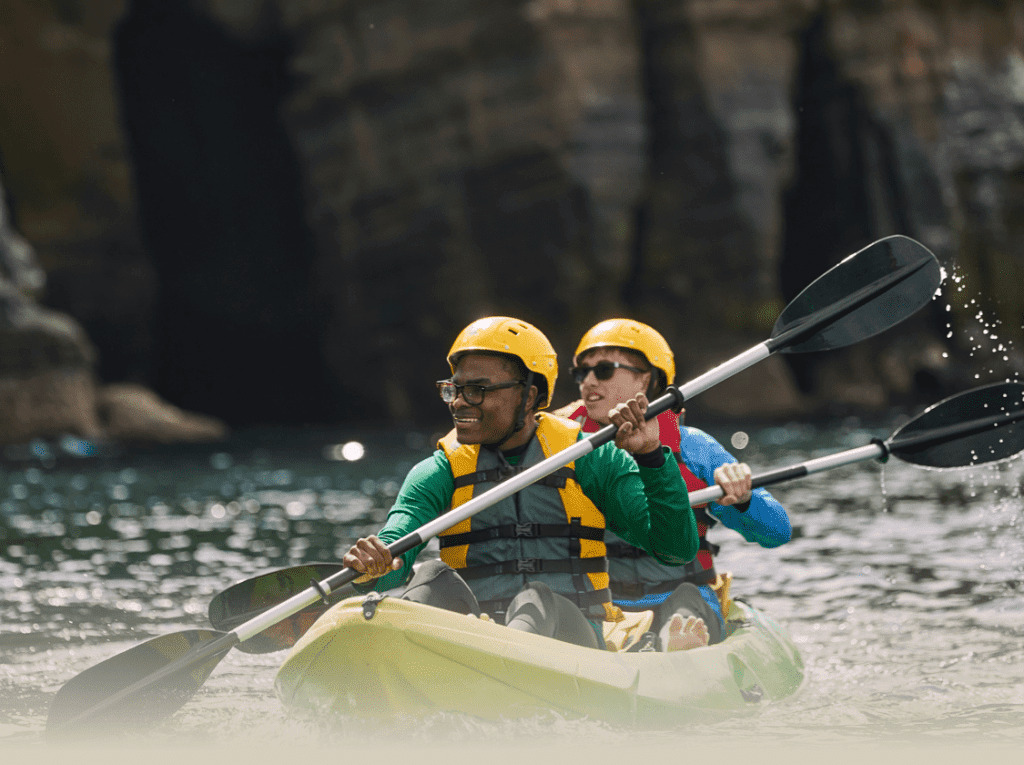 Scouts paddling kayaks during an outdoor activity